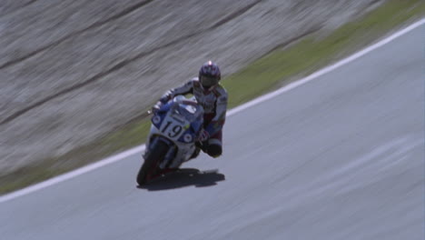 a motorcyclist rounds a turn in a racetrack