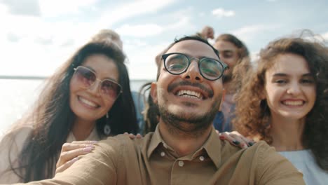 retrato de un árabe alegre bailando al aire libre con un grupo de amigos riendo disfrutando de una fiesta en la playa