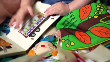 Close-up-of-baby-infant-hands-playing-with-soft-toys-and-clown-rattle