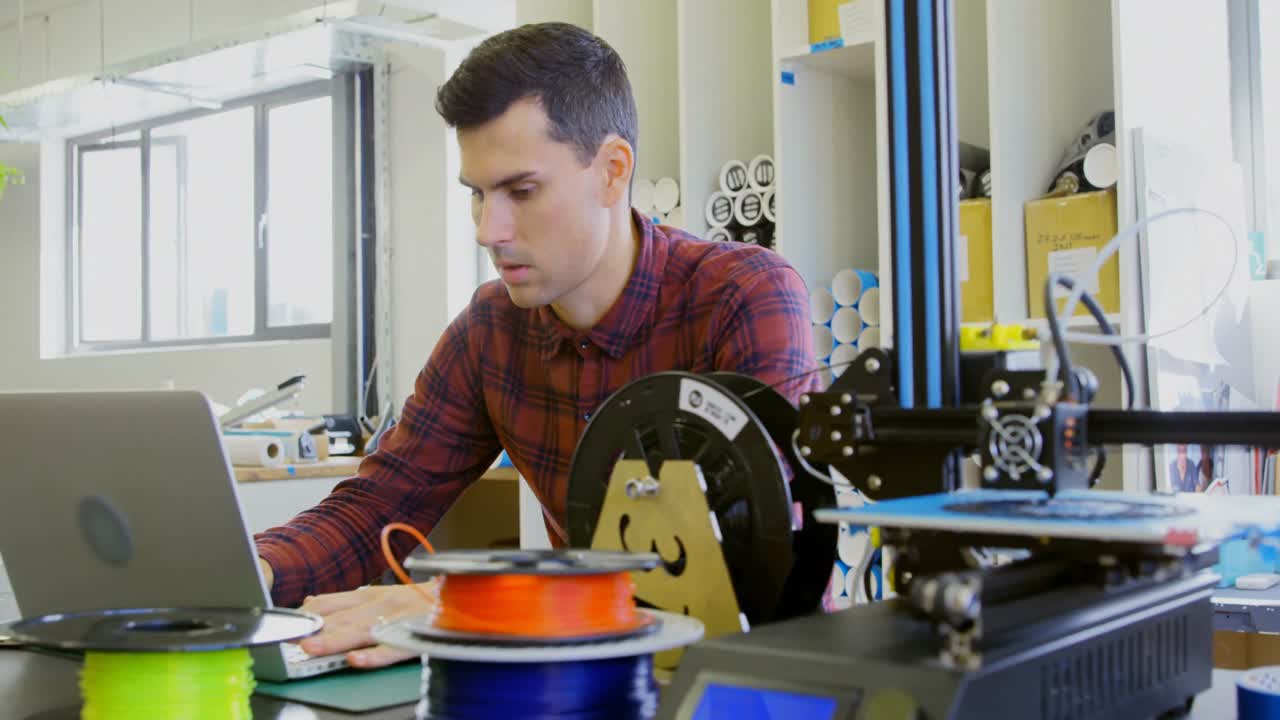 mecánico sosteniendo un anillo de cadena mientras usa una computadora portátil en el escritorio 4k