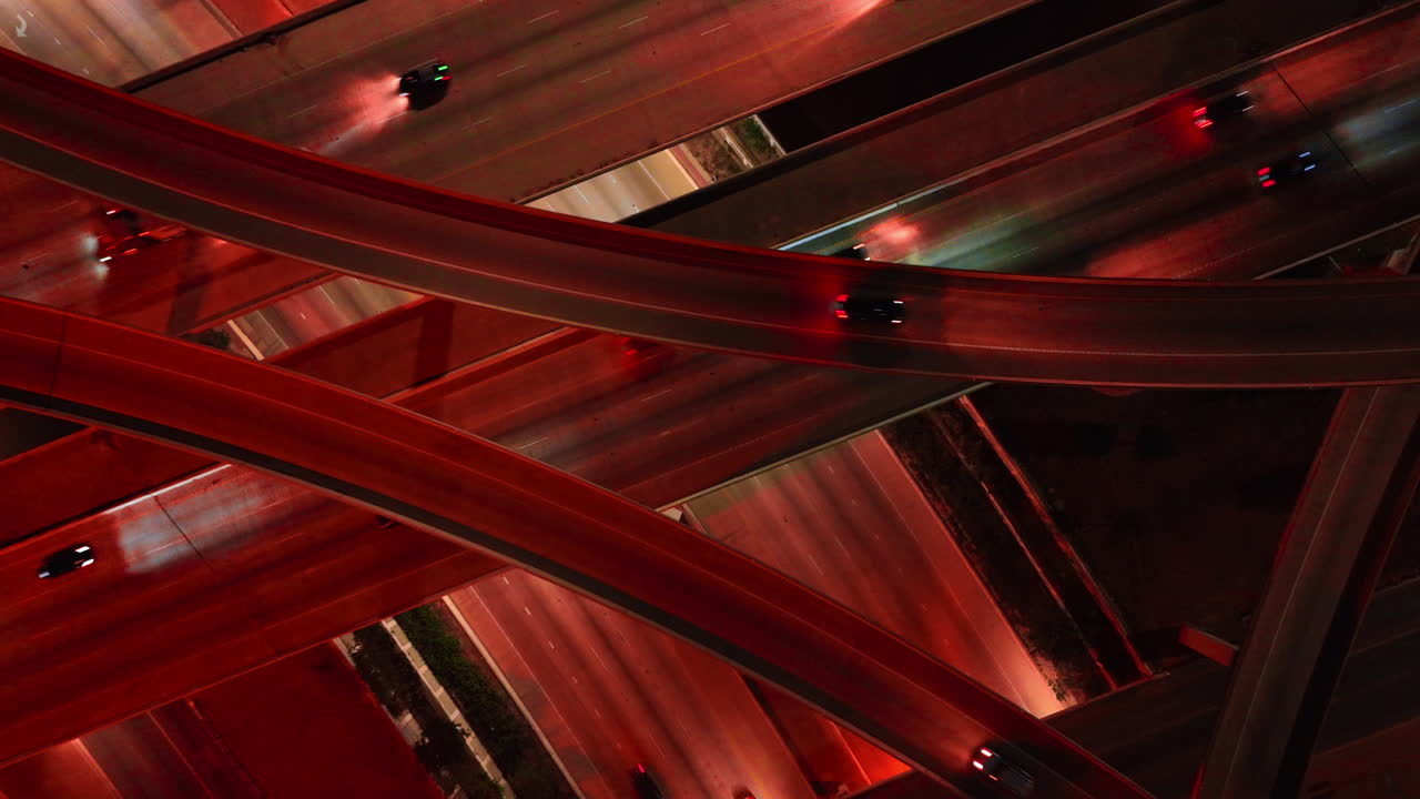 Going down above the lively multi-level interchange. Roads colored red from the street lights at night