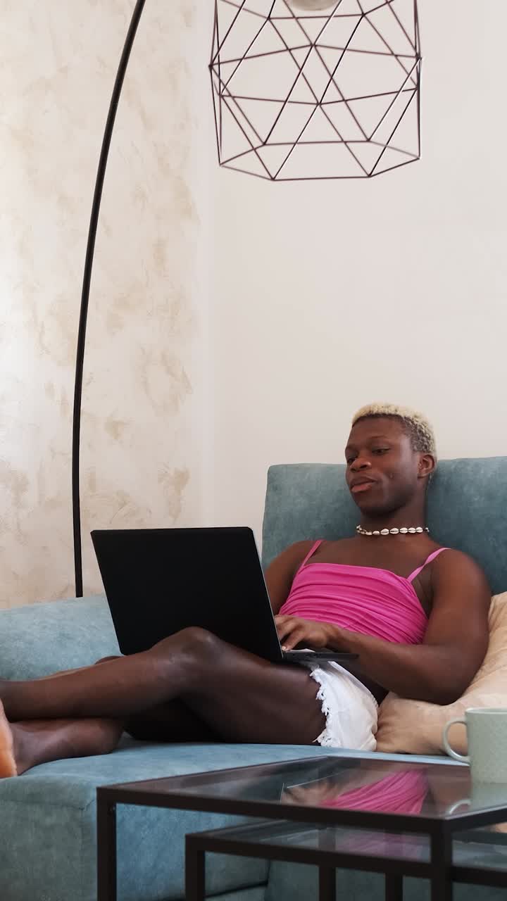 Person relaxing on a sofa using a laptop at home