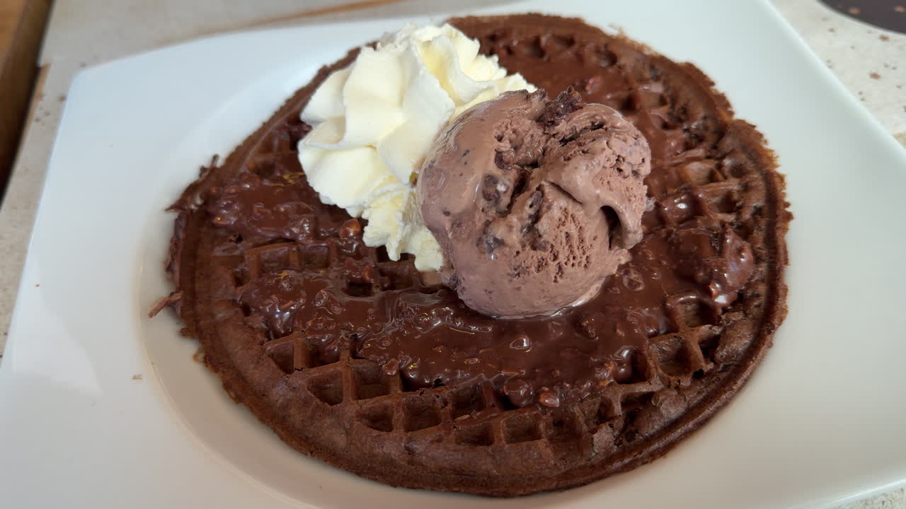 Closeup of a sweet waffle dessert with chocolate and ice cream