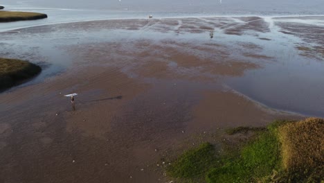 Surfista-Salir-Del-Agua-Con-Tabla-De-Surf,-Río-Vicente-Lopez-En-Buenos-Aires