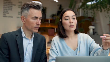 an business woman showing documents to a business man at a meeting in a coffe shop 1