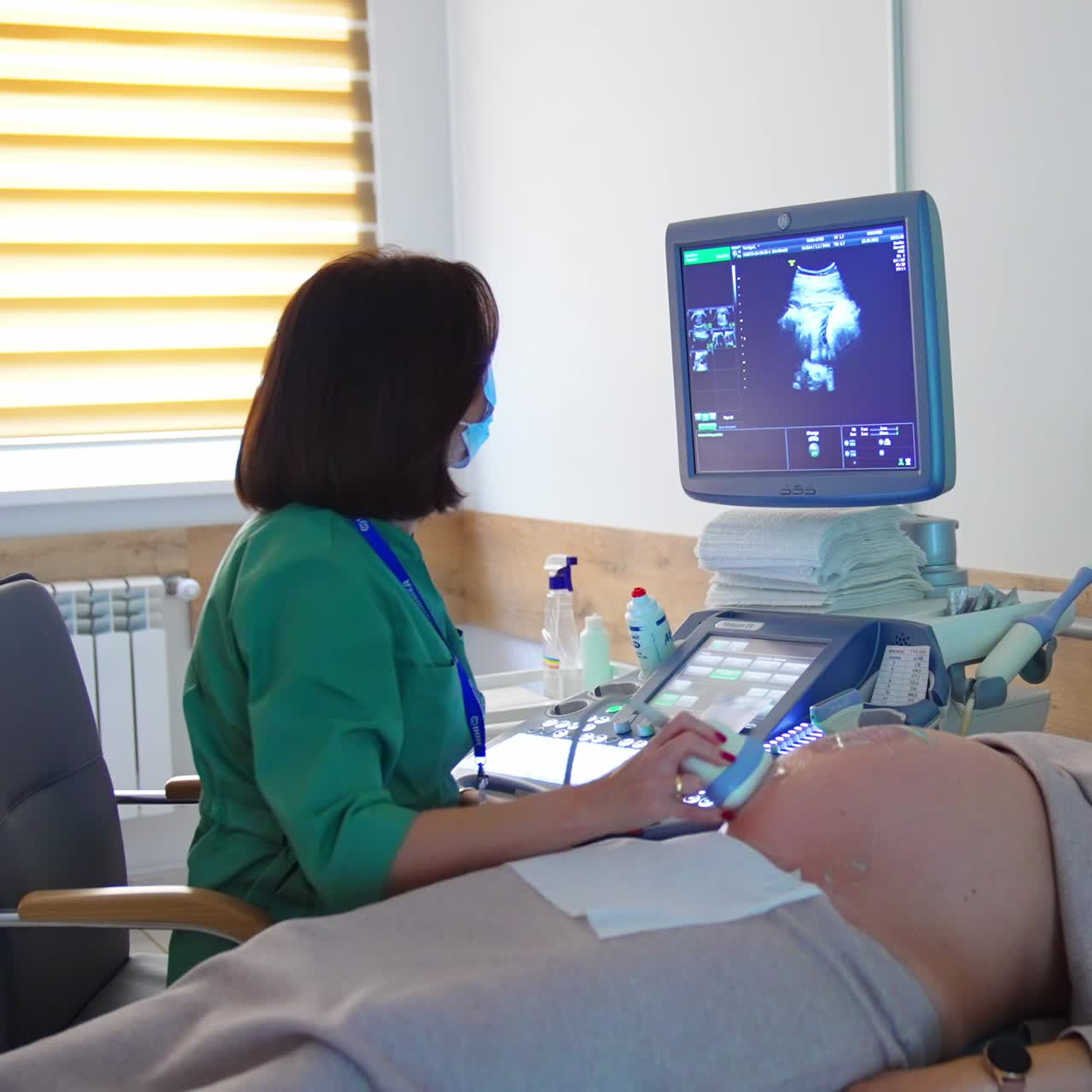 Woman at last stage of pregnancy is at doctor's check. Ultrasound examination at modern apparatus