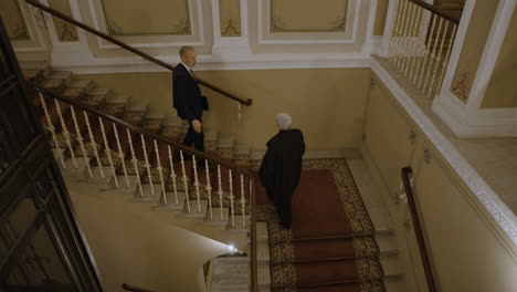 men meeting on grand staircase