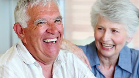 Senior-couple-smiling-at-the-camera-together