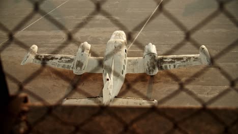 toma superior en cámara lenta del avión en el suelo detrás de una red de alambre de púas, toma del establecimiento cinematográfico del viejo avión abandonado, ruina de la soledad del aeropuerto de atenas elliniko