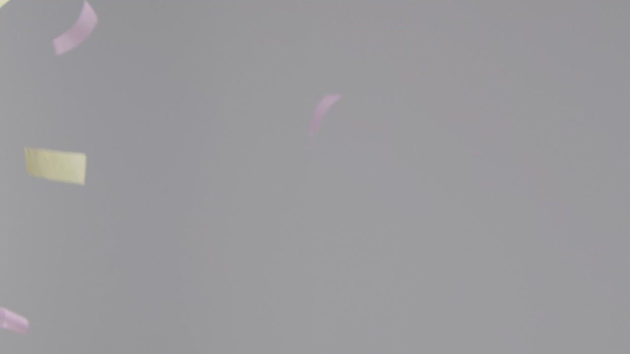 회색 배경에 떨어지는 컬러 스트립 색종이의 고정 샷