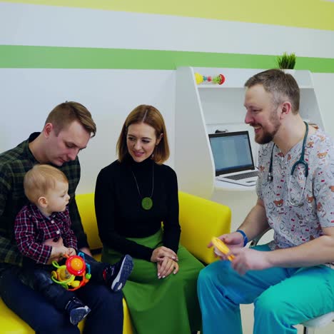 young family with a kid visit doctor. male pediatrician doing medical check-up to a little boy. baby doctor talks to a child at the healthcare center.