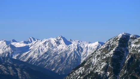 snow-capped mountain peaks against clear blue sky in vancouver island, bc, canada. wide shot