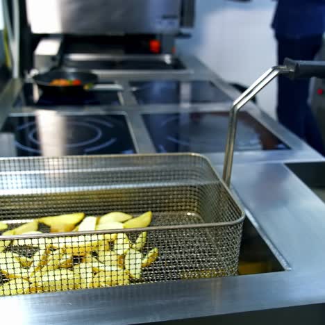 Ready fried potato in deep fryer. Cooked french fries in the modern kitchen restaurant. Delicious crispy potato. Junk food