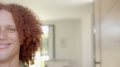 medio retrato de un hombre caucásico con cabello rojo y pecas sonriendo en casa, espacio de copia, cámara lenta