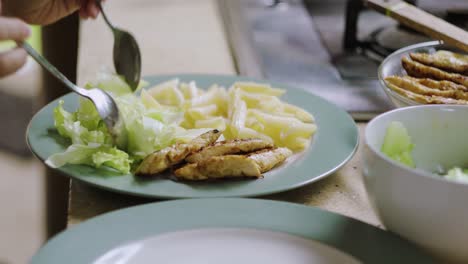 Sirviendo-Ensalada-En-Un-Plato-Con-Pollo,-Pasta-Y-Salsa