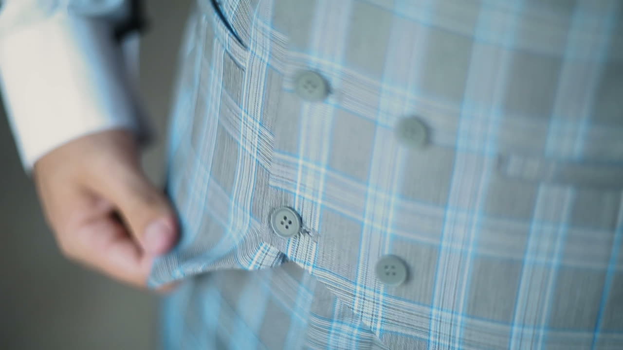 Man fastens buttons on his jacket. Businessman is wearing a jacket. Close up