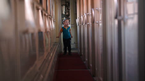 Happy-boy-running-along-the-train-hallway