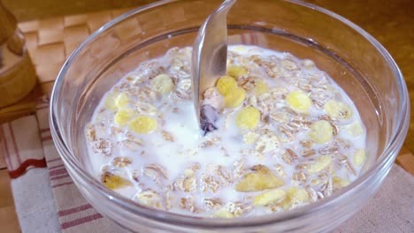 muesli de cereales de grano entero en un tazón para un delicioso desayuno matutino con leche. cámara lenta con toma de seguimiento de rotación.