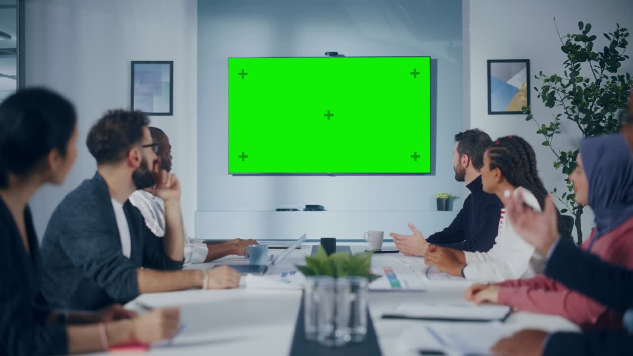 reunión en la sala de conferencias de la oficina multiétnica moderna: equipo diverso de gerentes exitosos, ejecutivos usan pantalla verde chroma key tv, celebran y aplauden el lanzamiento exitoso de productos de comercio electrónico