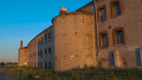 Footage-displays-a-prison-called-Patarei-prison-during-a-sunset-with-beautiful-architecture-shot-from-Tallinn-harbor-in-4k-located-in-Europe,-baltics