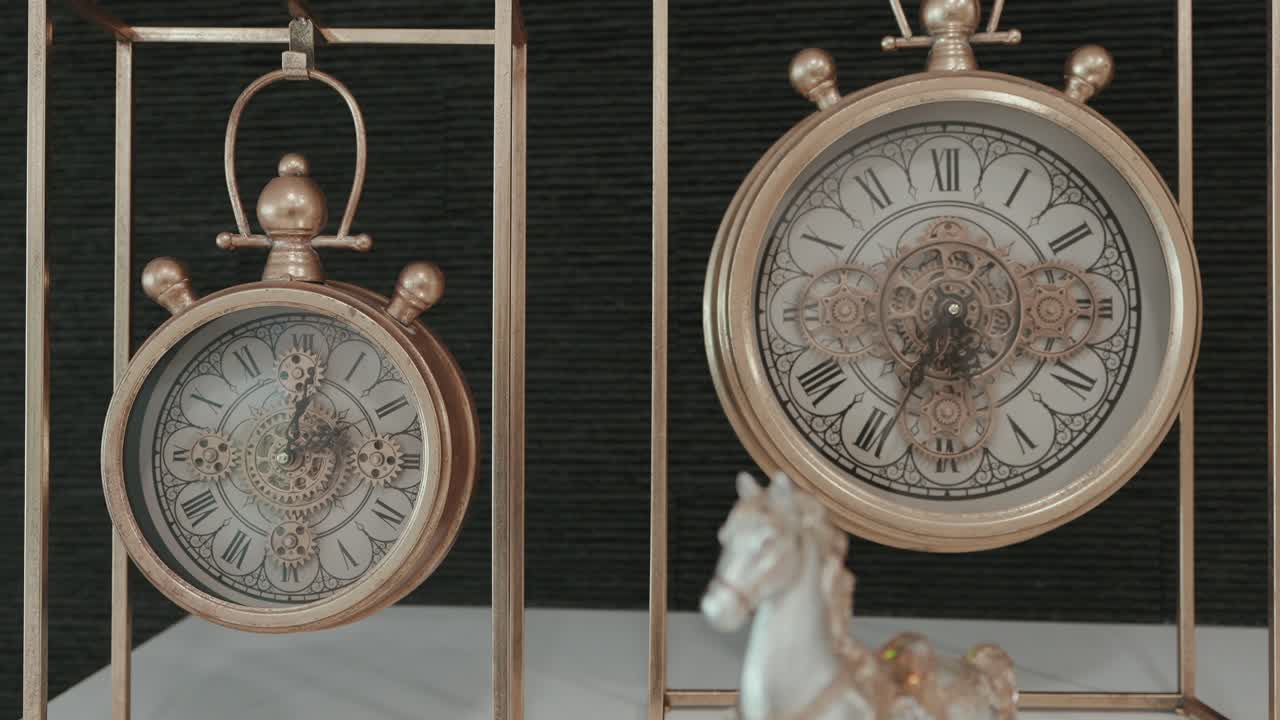 ornate twin clocks with roman numerals in brass metal frames