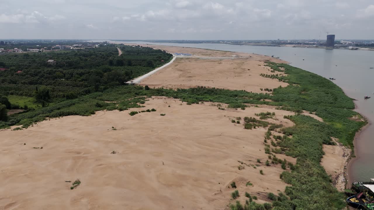 Drone footage above a big land cover by sand who soon will get houses and buildings, a new district in front of Phnom Penh, Cambodia along the Mekong banks