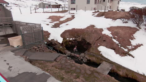 Ascend-view,-caucasian-woman-bathing-in-remote-natural-hot-spring,-next-to-pool