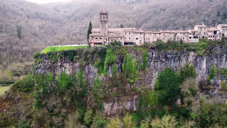 aerial view of buildings on top of a rocky mountain in san felíu de guixols in catalonia, spain