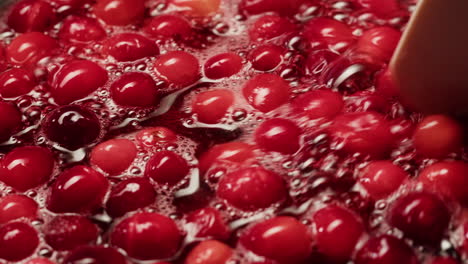 frozen cranberries cooking for tea or jam, background close up of cranberry berries in on the kitchen, chef making dessert healthy pie.