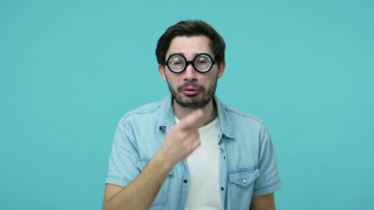 un geek cómico y torpe ajustando gafas dioptricas redondas, mirando a la cámara con una sonrisa estúpida y divertida, con problemas de visión