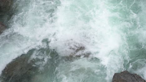 strong river rapids flowing over rocks, glacier meltwater, aerial top down