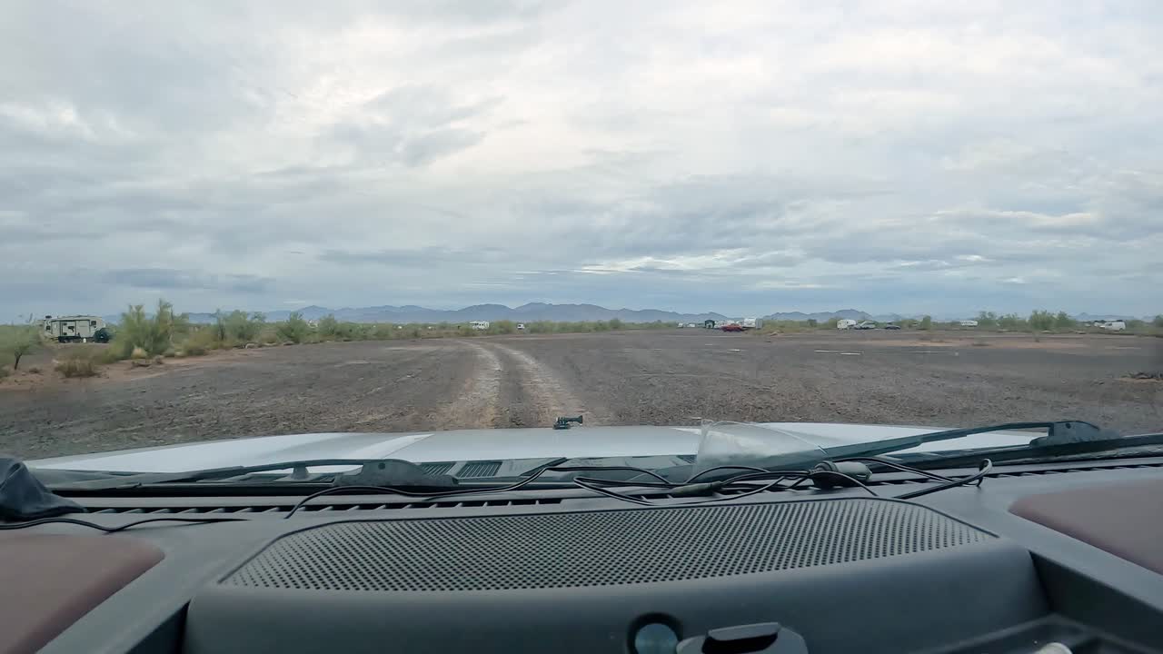비가 내리고 사막에서 캠핑 - 비가 오는 날 소노라 사막에서 어져있는 캠핑객들의 그룹을 통해 자갈 길을 운전하는 pov