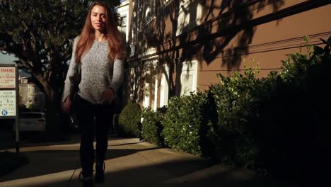 mujer caminando en una calle residencial de la ciudad