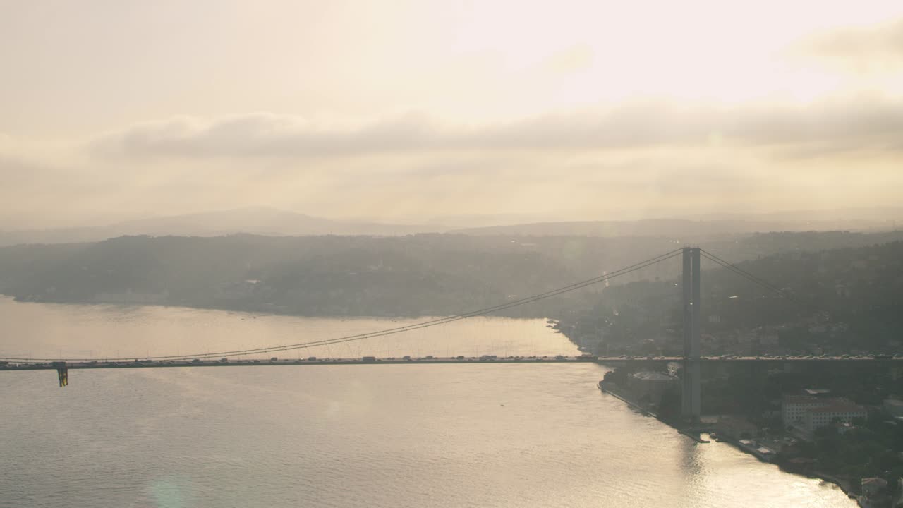 보스포루스 (bosphorus) 에 있는 다리와 해가 지는 동안 그 위에 있는 자동차.