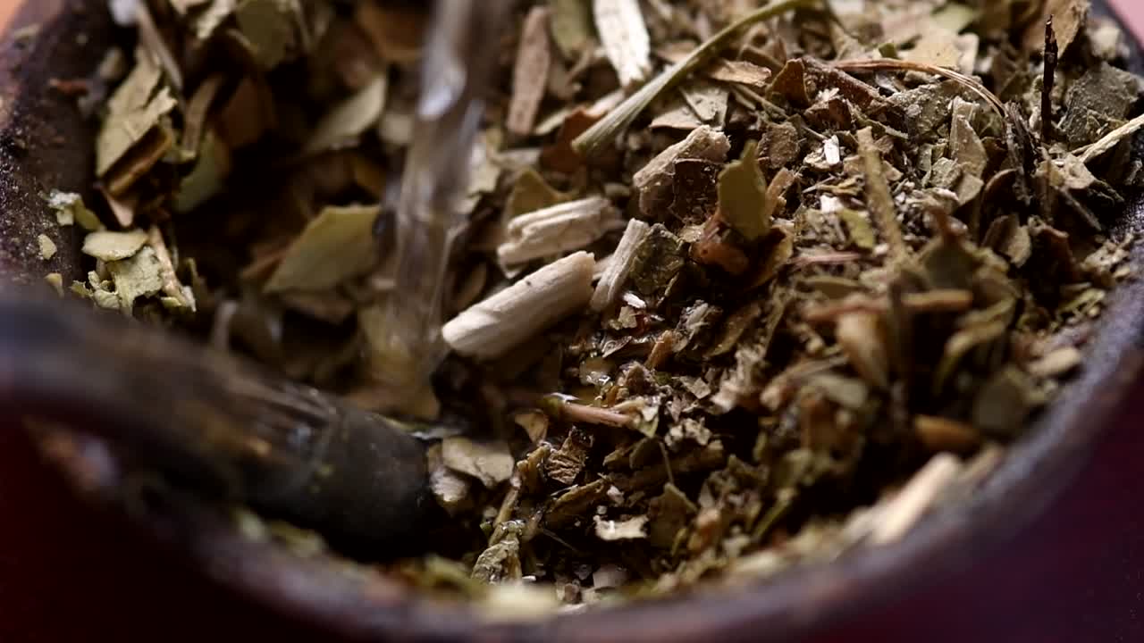 Pouring water into a "mate" gourd. Traditional Argentinian infusion. High angle view. Closeup