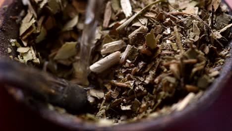 pouring water into a "mate" gourd. traditional argentinian infusion. high angle view. closeup