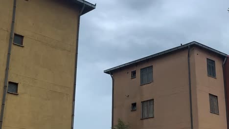 airplane fly between two condominium building blocks day exterior shot