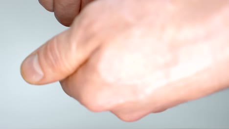 한 남자는 손에 든 사소한 것을 조심스럽게 조사하고, 올바른 동전을 찾으려고 노력합니다.