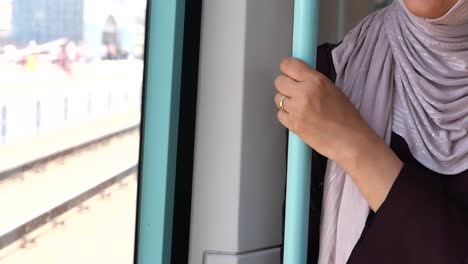 person's hand holding a pole inside a moving train or tram