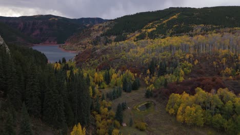 Drone-following-Aspen-canyon-to-lake-in-early-morning-during-fall