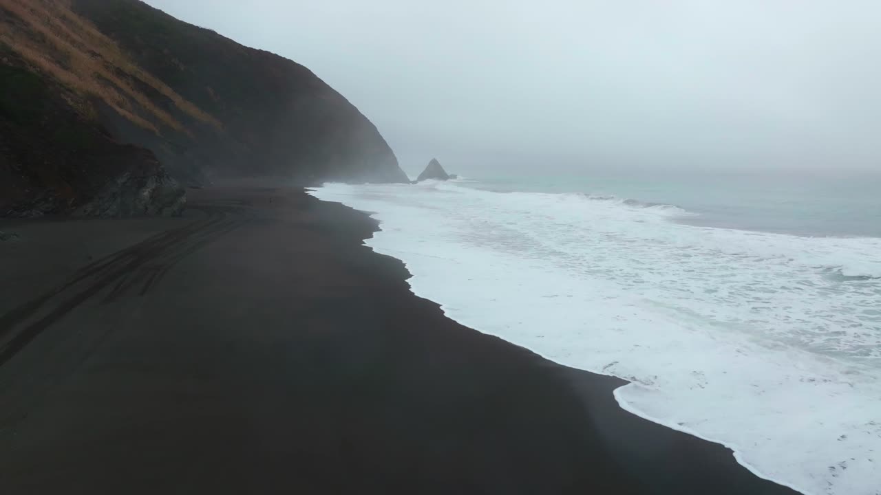 USAL Beach campground 4wd car truck tracks black sand mist rain fog Lost Coast Trail aerial drone California PNW waves crashing early morning rugged coastline Chimney Rocks forward up motion