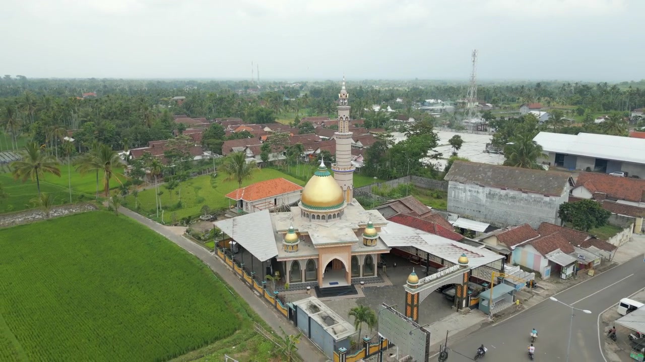 Maaseudun moskeija riisipeltojen ympäröimänä Bondowosossa, Itä-Jaavalla, Indonesiassa. Drone-seuranta taaksepäin 4K 60FPS -laadulla.