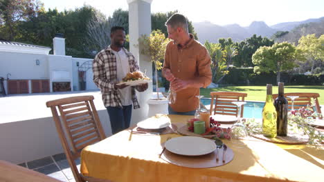 happy diverse male and female friends serving thanksgiving celebration meal in sunny garden