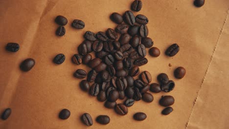 Vintage-look-of-coffee-beans-on-old-paper-rotating-4K-video-from-top