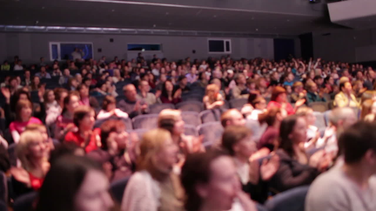Persone sfocate applaudono dopo la prima
