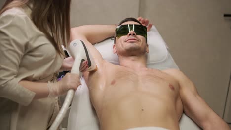 man armpit area during procedure of laser hair removal in modern cosmetology clinic. concept of man beauty, cosmetology, epilation