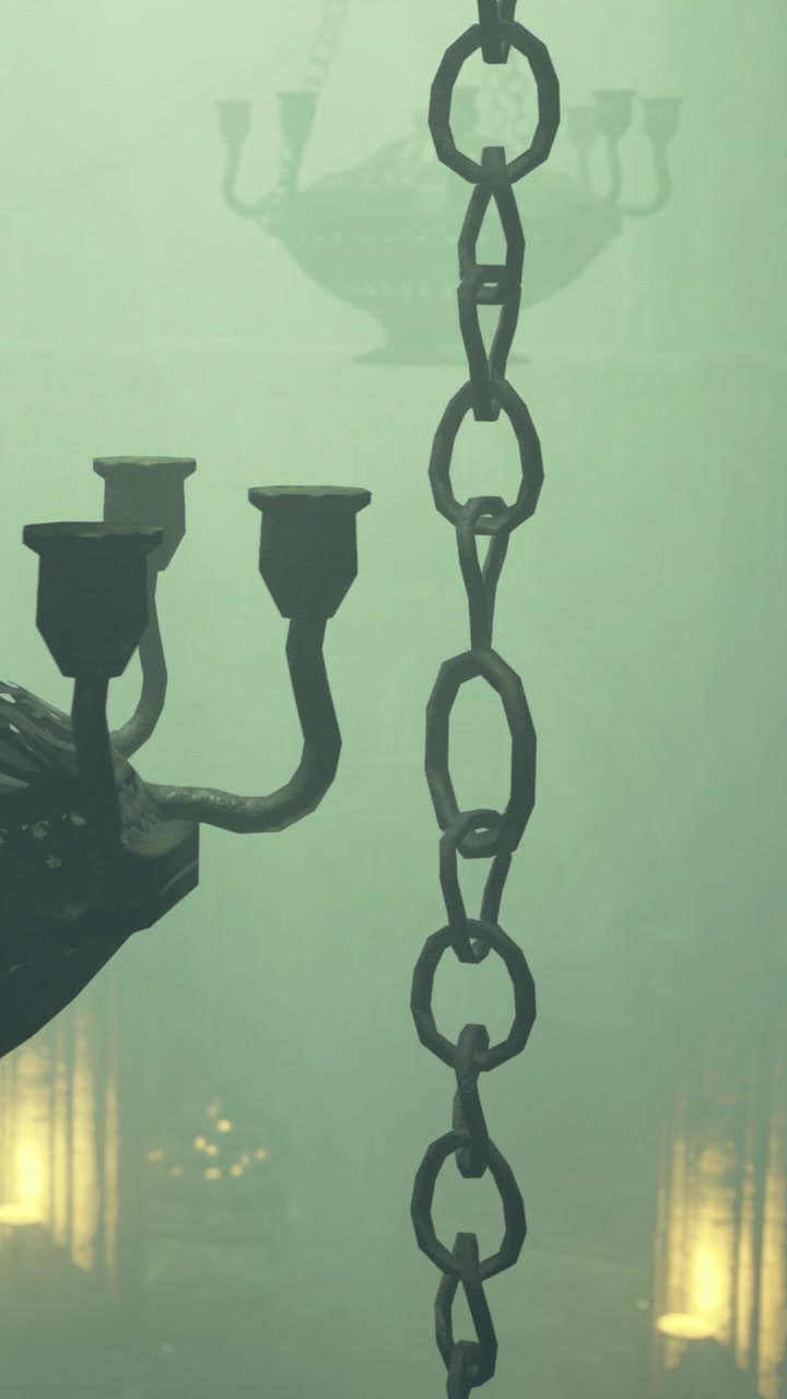 Lampadario e catene in penombra con nebbia, visti durante un evento serale.