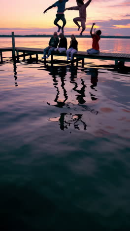 friends enjoying a vibrant sunset on a lake dock, jumping and relaxing