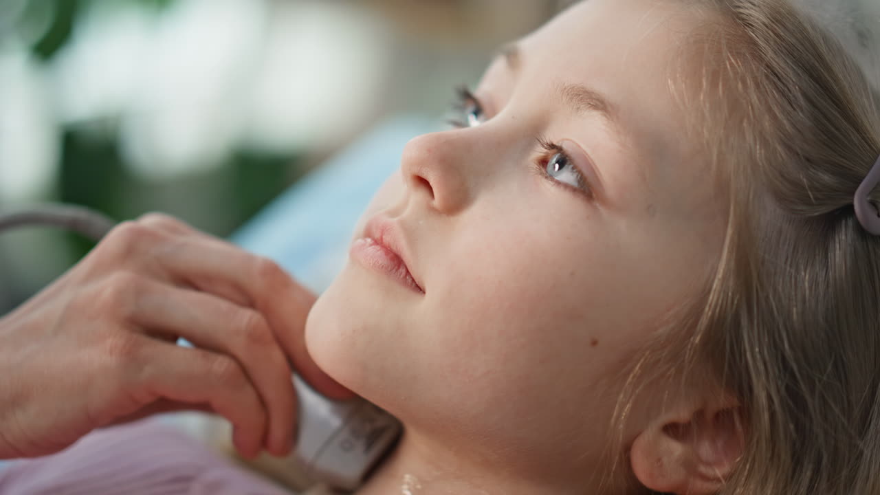 Hand performing ultrasound examination of girl. Closeup pediatric patient visit