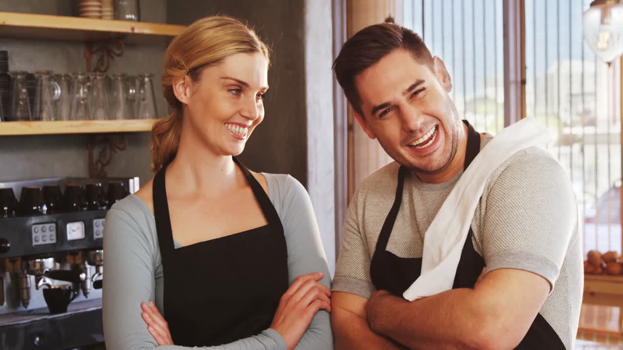 Cheerful owners standing with arms crossed